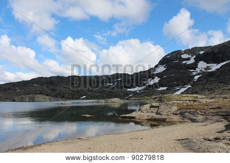 Mountains lake and blue sky with some clouds.