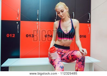 Before training. Girl in a gym locker room