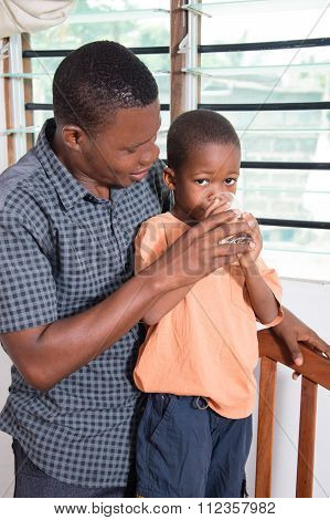 Dad gives water to drink to his child.