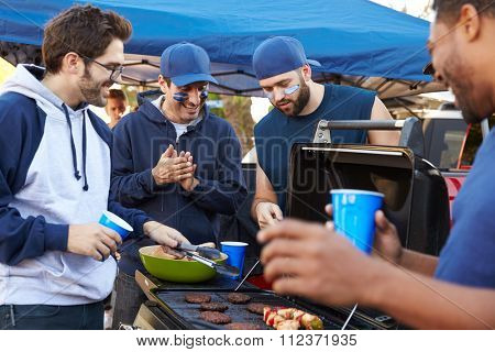 Group Of Male Sports Fans Tailgating In Stadium Car Park