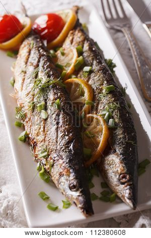 Fish Saury Grilled With Lemon And Chives On A Plate Close-up. Vertical