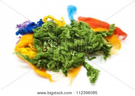 Multi-colored piece of Australian sheep wool Merino breed close-up on a white background