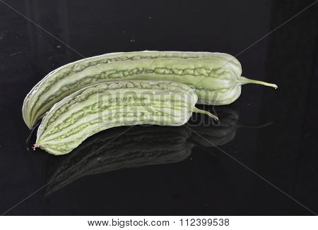 bitter gourd and reflection on black counter