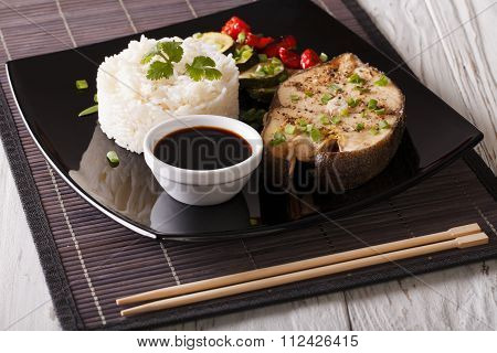 Baked Fish, Rice, Vegetables And Soy Sauce On A Plate Close-up
