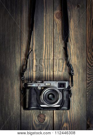 Retro film photo camera on the wooden background.