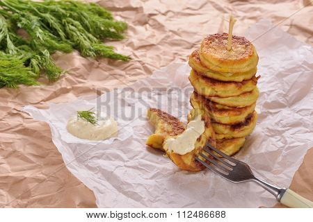 Potato Pancakes On Kraft Paper With Dill And Garlic Sauce