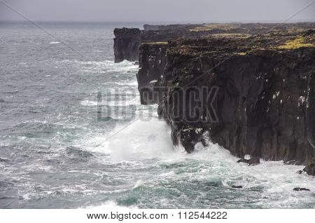 Waves Breaking On Black Rocks In Iceland
