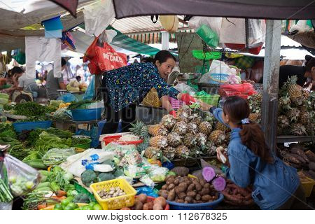 Vietnamese woman is selling fruits and vegetables at the wet market