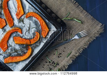 Slices of baked pumpkin on baking tray