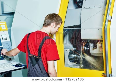 mechanical industrial worker at cnc milling machine center in tool manufacture workshop