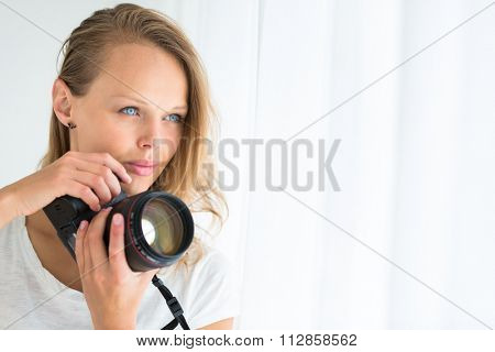 Pretty, female photographer with digital camera - DSLR and a huge telephoto lens (color toned image; shallow DOF)