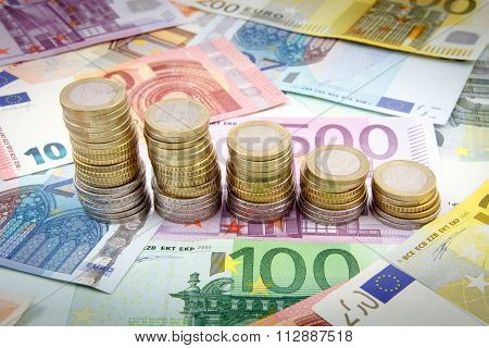 Decreasing stacks of euro coins on euro banknotes