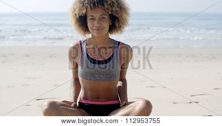 Fit smiling woman sits on the beach slow motion