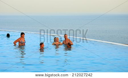 Sharm-El-Sheikh, Egypt - August 27, 2017: People are swimming in the infinity pool at the tropical sea resort at sunset. Infinity pool is an attribute of luxury resort or property estate.