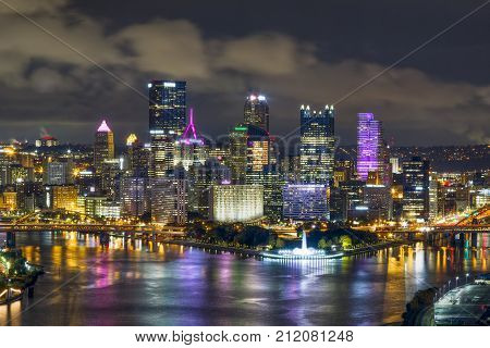 The city of Pittsburgh Pennsylvania shines at night where the Allegheny and Monongahela Rivers meet to form the mighty Ohio.