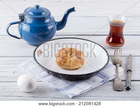 turkish borek boyoz with egg and tea on wooden background