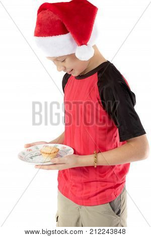 Pre-teen boy in christmas hat and a mince pie