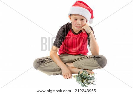 Sad pre-teen boy with mistletoe isolated on white background