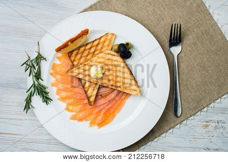Smoked salmon with fresh dill on bread slice, in natural light, authentic food.