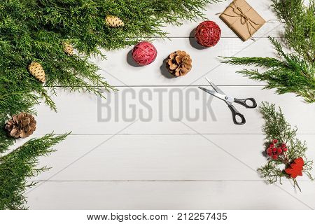 Juniper branches with a Christmas decor. Christmas, New Year background. Coniferous branches of juniper. Top view, flat design. Christmas tree on white wooden background.