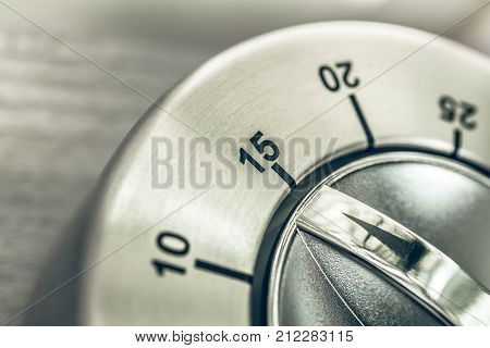 15 Minutes - Quarter Hour - Macro Of An Analog Chrome Kitchen Timer On Wooden Table