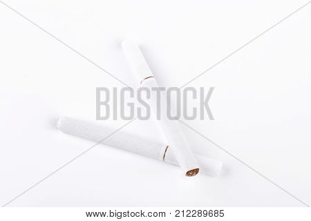 Two white cigarettes on white background. Tobacco cigarettes with filter isolated on white background.