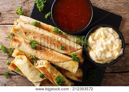 Taquitos With Chicken And Cheese Close-up, As Well As Sauces. Horizontal Top View