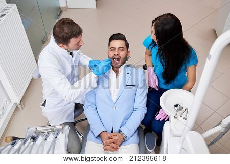 Top view shot of a handsome young man having oral checkup at the dentist office professionalism doctor occupation service helpful assistance healthcare medicine lifestyle wellbeing concept.