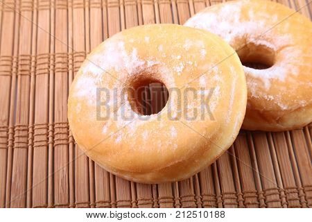 Homemade Doughnuts with Jelly filled and powdered sugar on Bamboo tablecloth. Selective focus