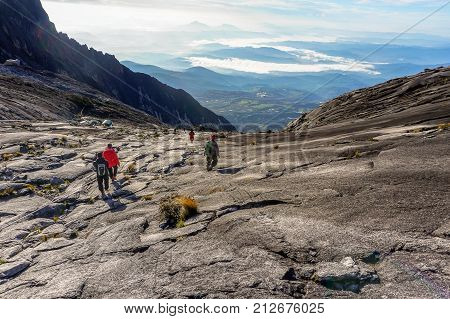 Ranau,Sabah,Borneo-March 13,2016:Mountain Climbers carefully stepping down on the granite rocky mountain from Low's Peak to Sayat Sayat check point after successfully completed conquering the mountain Kinabalu at Sabah,Malaysia.