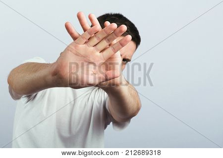 ban, caucasian, object, lifestyle, bankruptcy, denunciation, gesture, prohibit, beautiful, people, fashion, male, mood, rejection, denial, guy, everyday, hand, color, wall, conviction, background, person, feeling, emotion, white, cute, no, symbol, sign, b