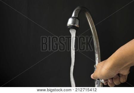 hand turning off water valve in concept saving water for future