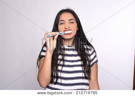 Close-up woman brushing her teeth. Isolated white background.