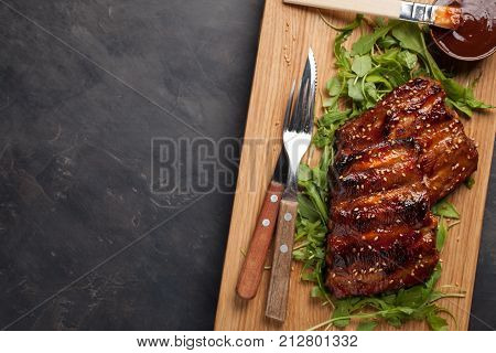 Closeup Of Pork Ribs Grilled With Bbq Sauce And Caramelized In Honey On A Bed Of Arugula. Tasty Snac