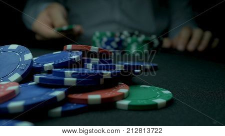 Close-up Of Man Throwing A Poker Chips. Close-up Of Hand With Throwing Gambling Chips On Black Backg