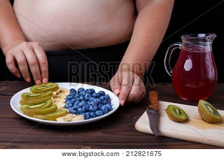 Overweight Fat Woman Making Fruit Plate. Healthy Tasty Low-calorie Dessert For Weight Losing