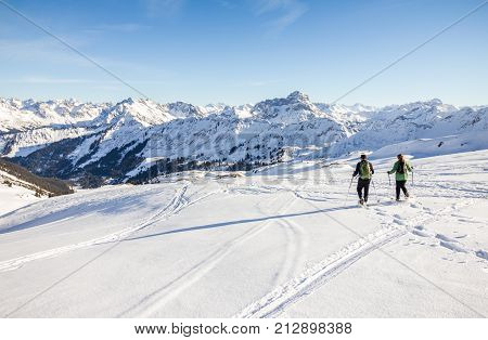 Couple hiking with snowshoes in winter mountain landscape. Alps in Germany, Bavaria, Allgau.