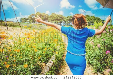 Asian women travel sleep relax. Women dress up hill tribe. Walk in the flower garden Cosmos sulphureus. Thailand