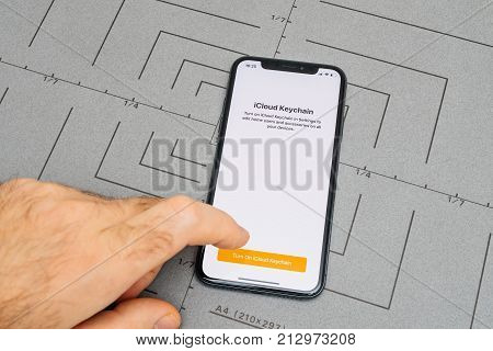 PARIS FRANCE - NOV 9 2017: Male hand touch selecting New Apple iPhone x 10 smartphone after unboxing and testing the iCloud keychain