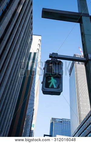 Traffic Green Light For People, Pedestrian And Human To Cross The Street With Background Of Office B