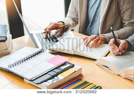 High School Or College Students Studying And Reading Together In Library