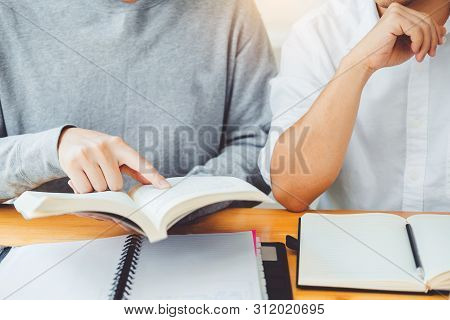 High School Or College Students Studying And Reading Together In Library