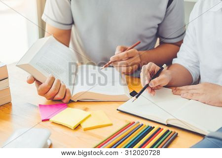 High School Or College Students Studying And Reading Together In Library