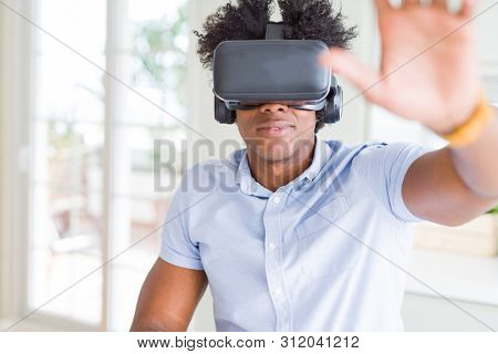 African amaerican man having fun playing with virtual reality glasses