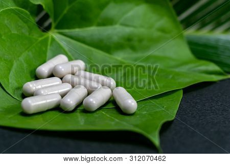 Natural Aurveda Concept - Close Up View Of Herbal Medicine On Green Leaf In Dark Background