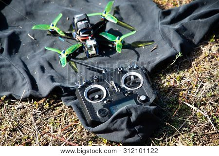 Fpv Racing Drone And Black Transmitter On The Floor