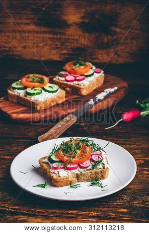 Vegetarian Sandwich With Fresh Sliced Tomatoes, Cucumber And Radish On White Plate