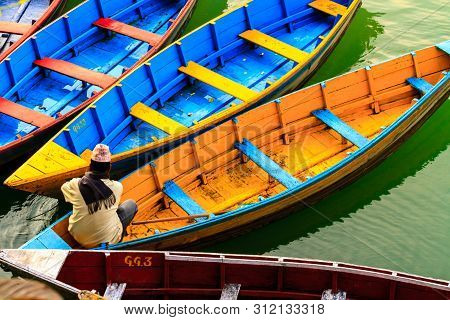 Pokhara, Nepal - November 21, 2015: Man Sitting In The Colorful Boat On Phewa Lake In Pokhara.