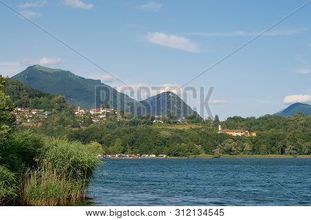 Beautiful Lakeside View On The Village Of Agnuzzo, Mount Monte Boglia And Mount Monte Bre In The Lug