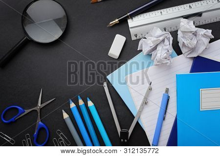 school supplies on black chalkboard background. back to school
